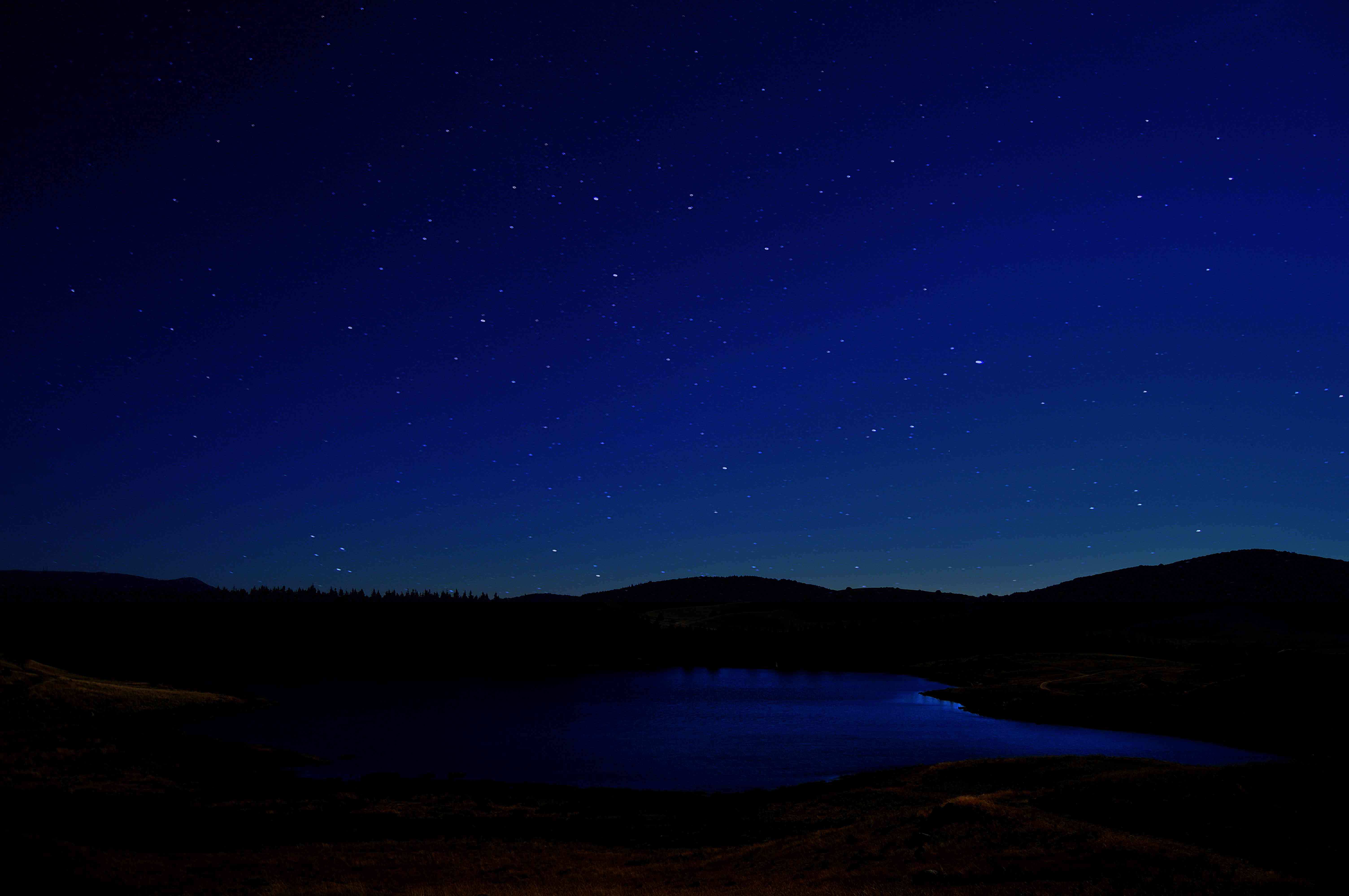 繁星闪烁的夜晚,天空在塞文山脉山脉和湖泊”width=