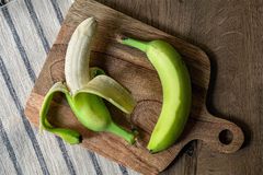 两根绿香蕉放在木砧板上