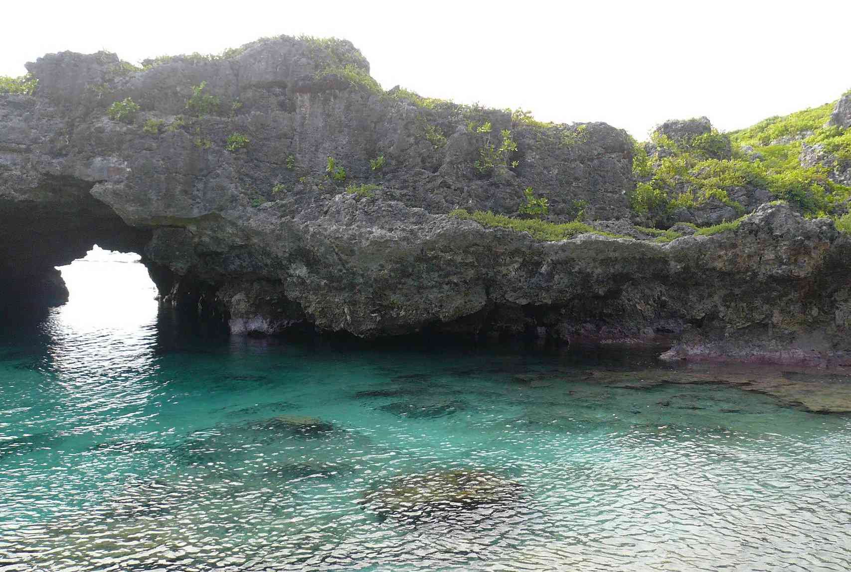 拱形的岩层延伸在清澈的热带水域上