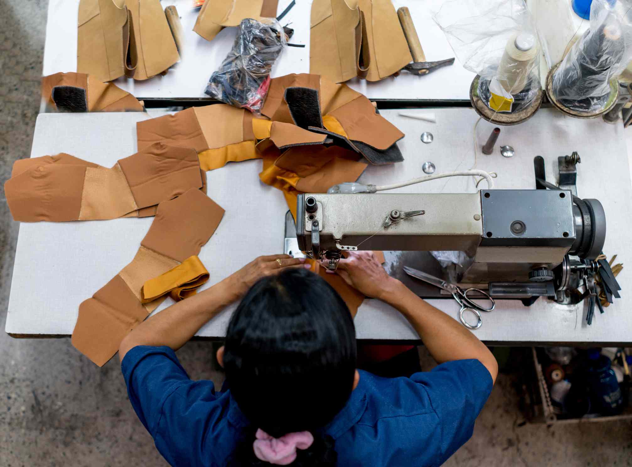 在一家制鞋工厂工作的妇女＂width=