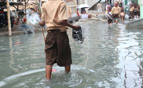 Child wading in knee-deep water during flood