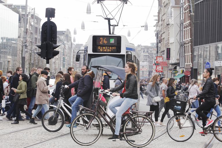 人们步行，骑自行车和在阿姆斯特丹的交通工具上“class=