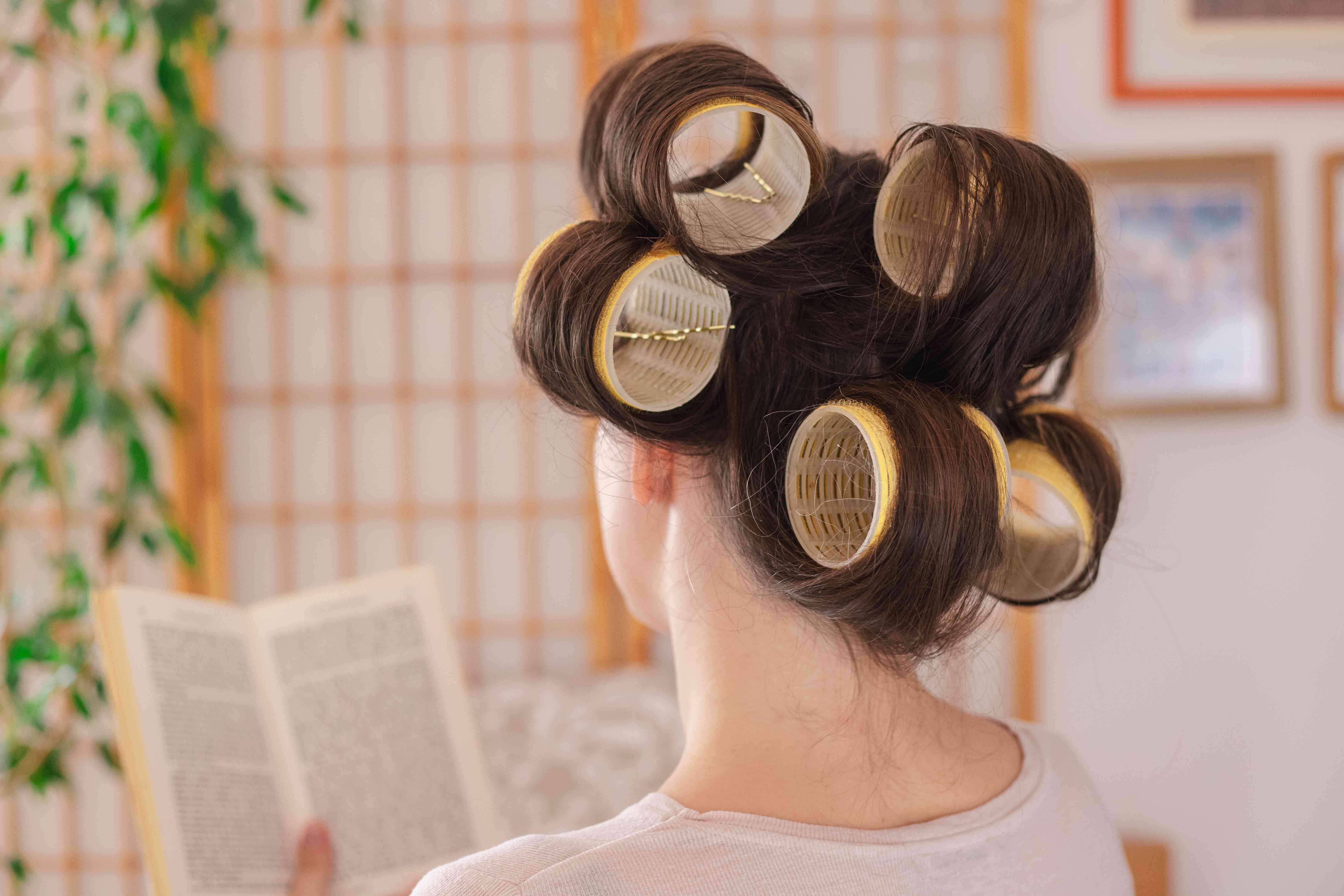 女人看书的背影，头发固定在超大的滚轴和发夹上