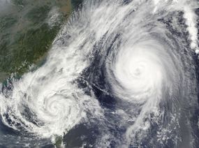 两个热带气旋相互作用的卫星图像。＂width=