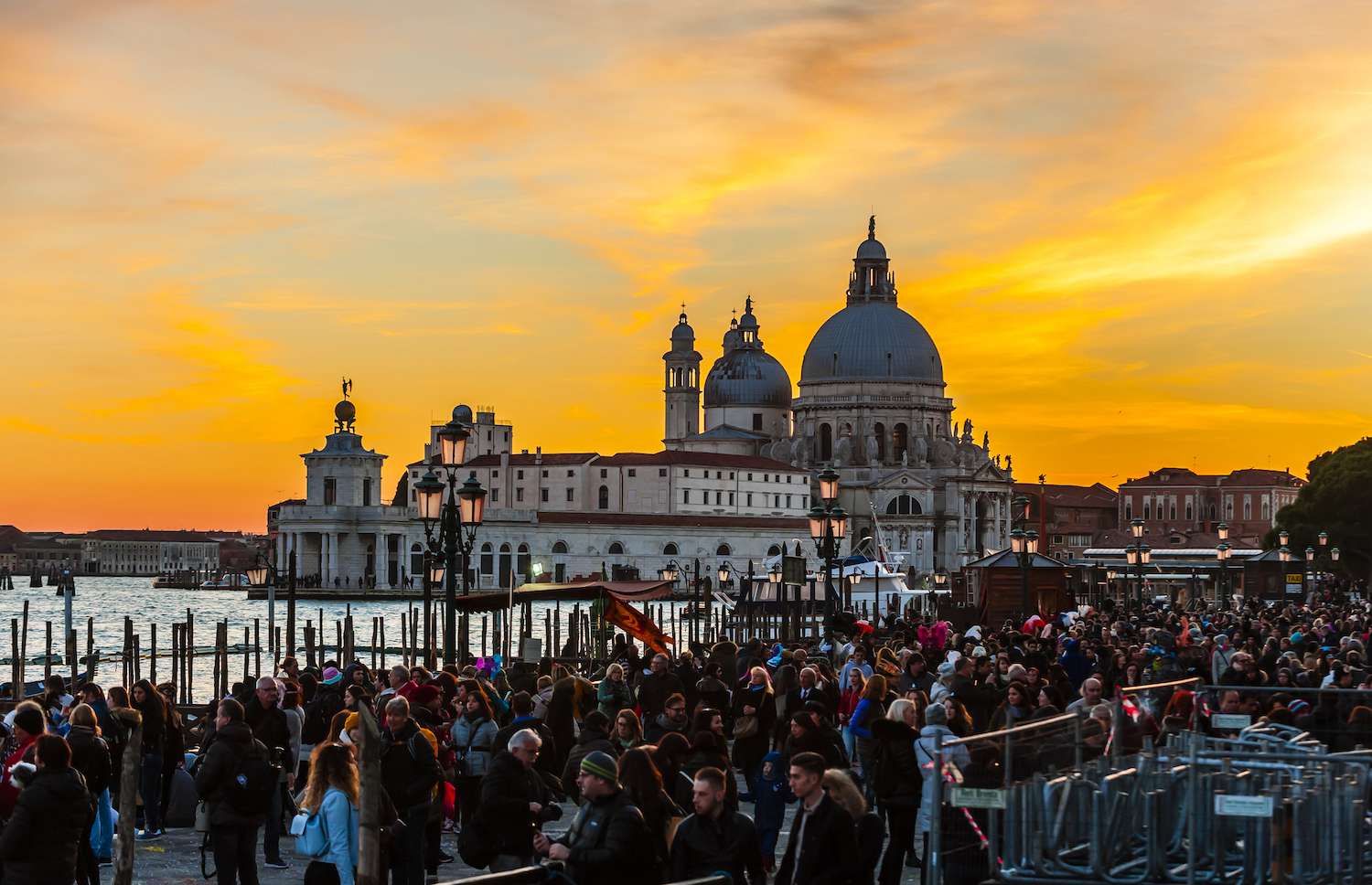 日落时分，一大群人聚集在威尼斯圣马可广场附近。