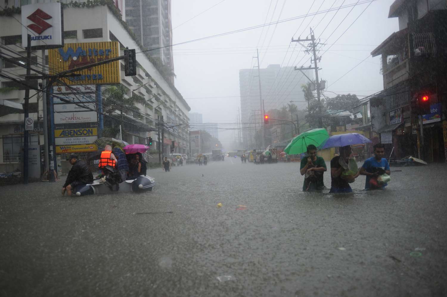 马尼拉居民试图通过被洪水淹没的街道