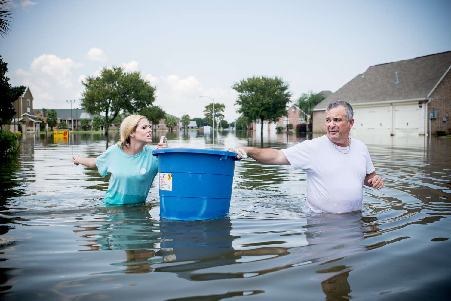 德克萨斯州阿瑟港，居民蹚过被洪水淹没的街道