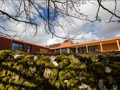 a modern building with mossy stones in front