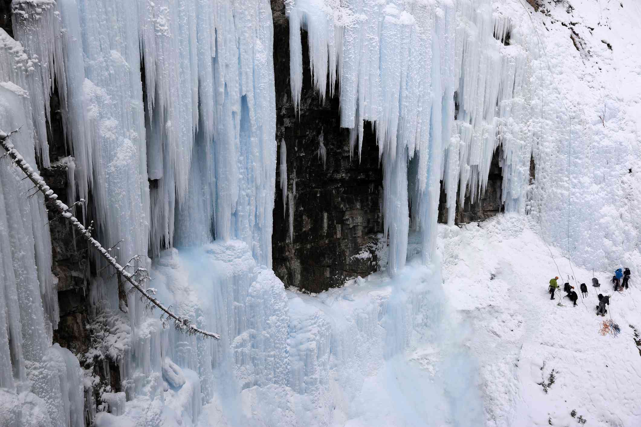 攀冰者聚集在结冰的瀑布底部
