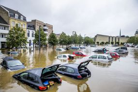 看到汽车在2021年7月15日在荷兰瓦尔肯堡（Valkenburg）的一条被洪水泛滥的街道上漂浮。“width=