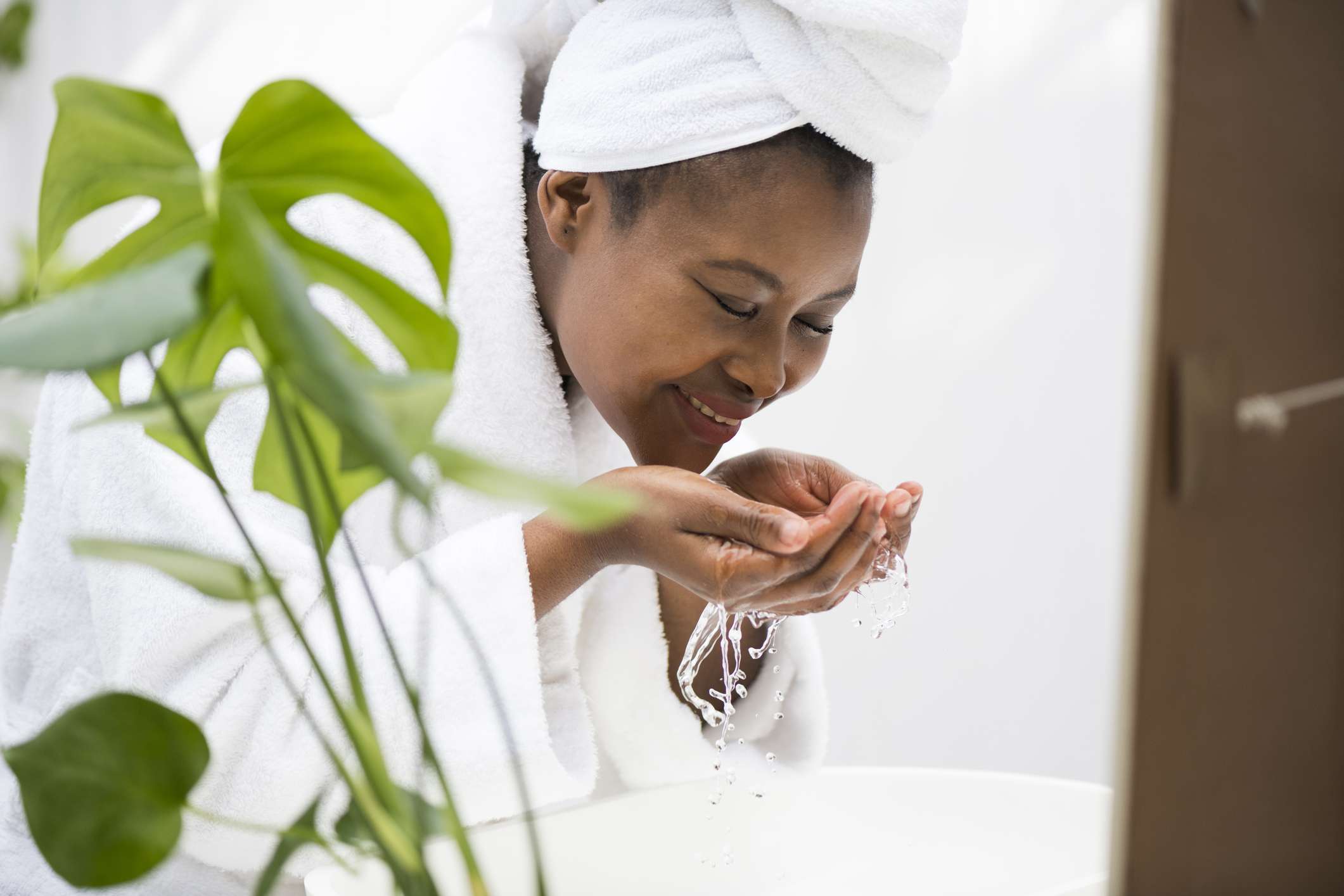 一位黑人妇女用水洗脸。