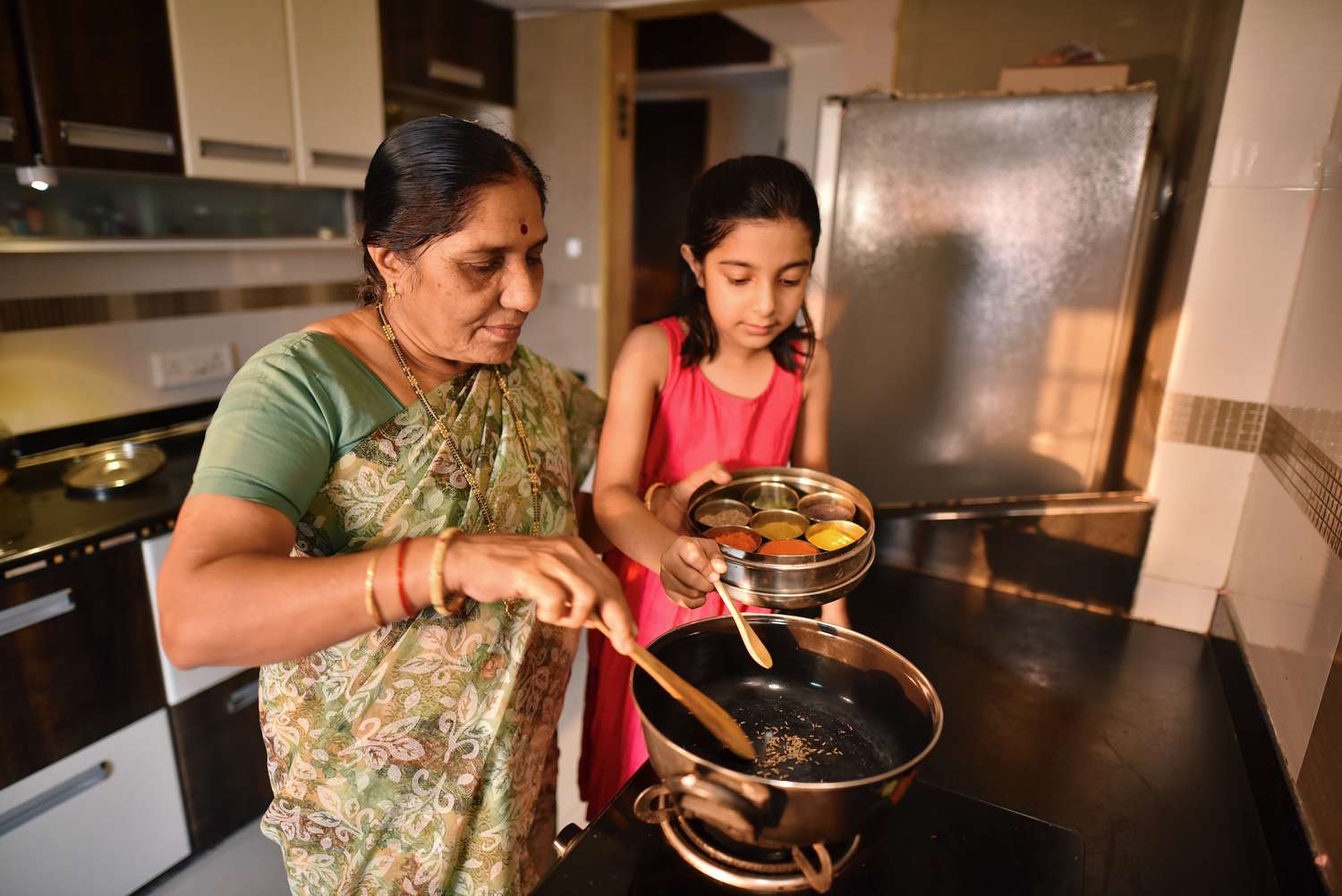 祖母和孙女用印度香料做饭