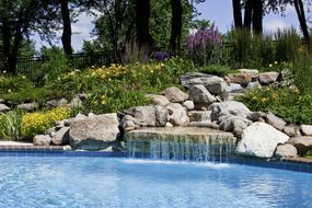 美丽的瀑布池边的石头＂width=