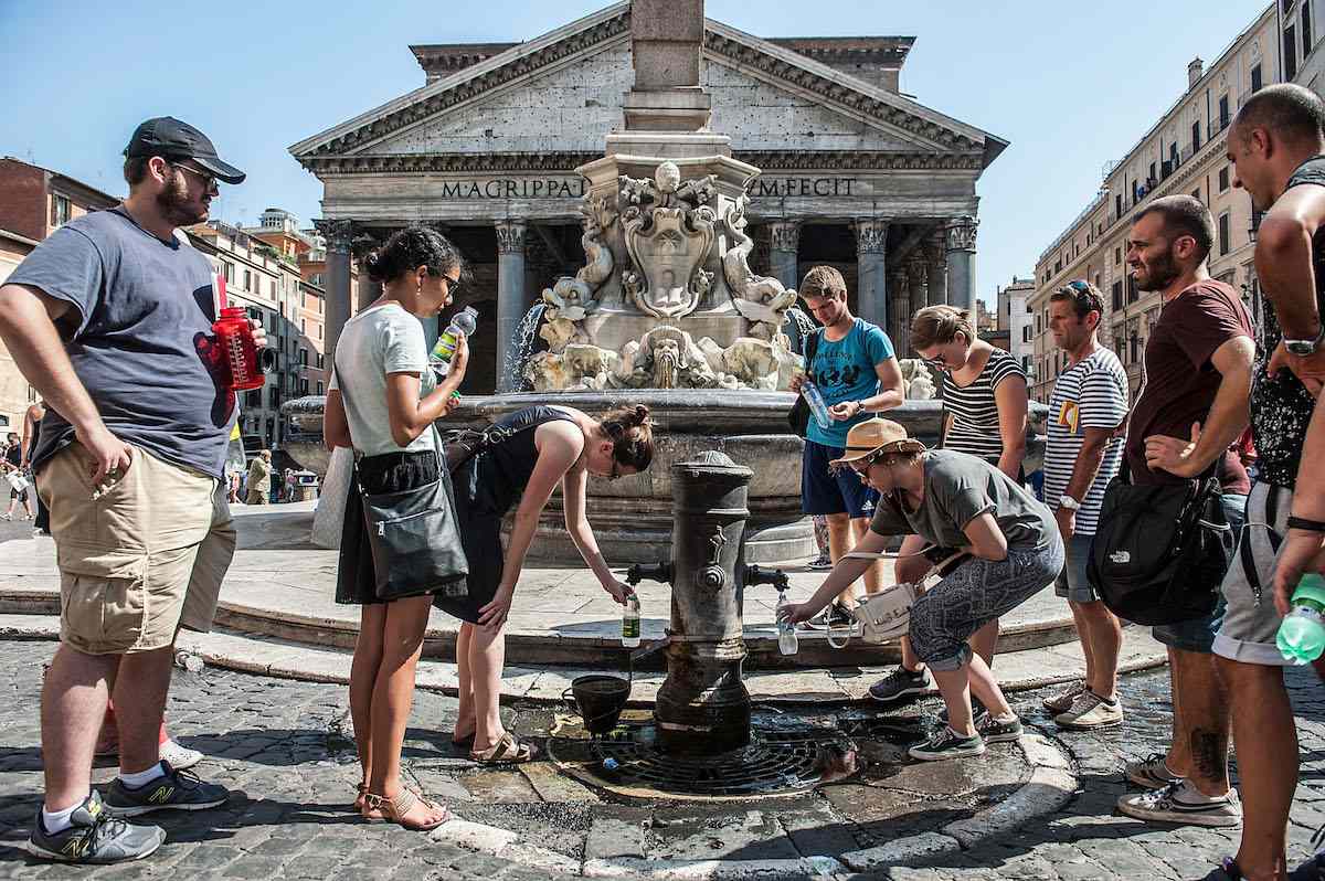2015年，意大利罗马，气温上升，游客在万神殿广场的喷泉里往瓶子里注水。＂width=