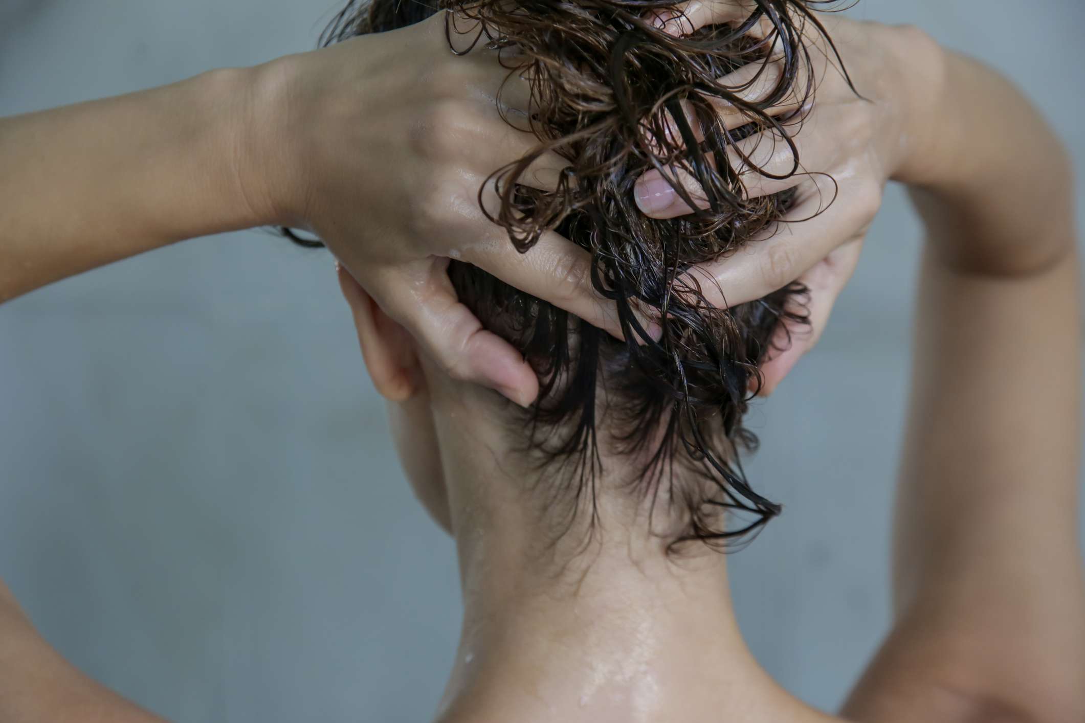 一名妇女在淋浴时用手按摩头皮。