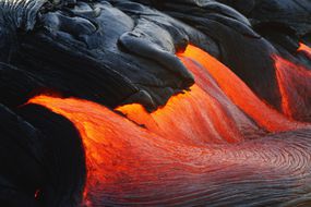 夏威夷基拉韦厄火山喷发时熔岩流倾泻而下＂width=