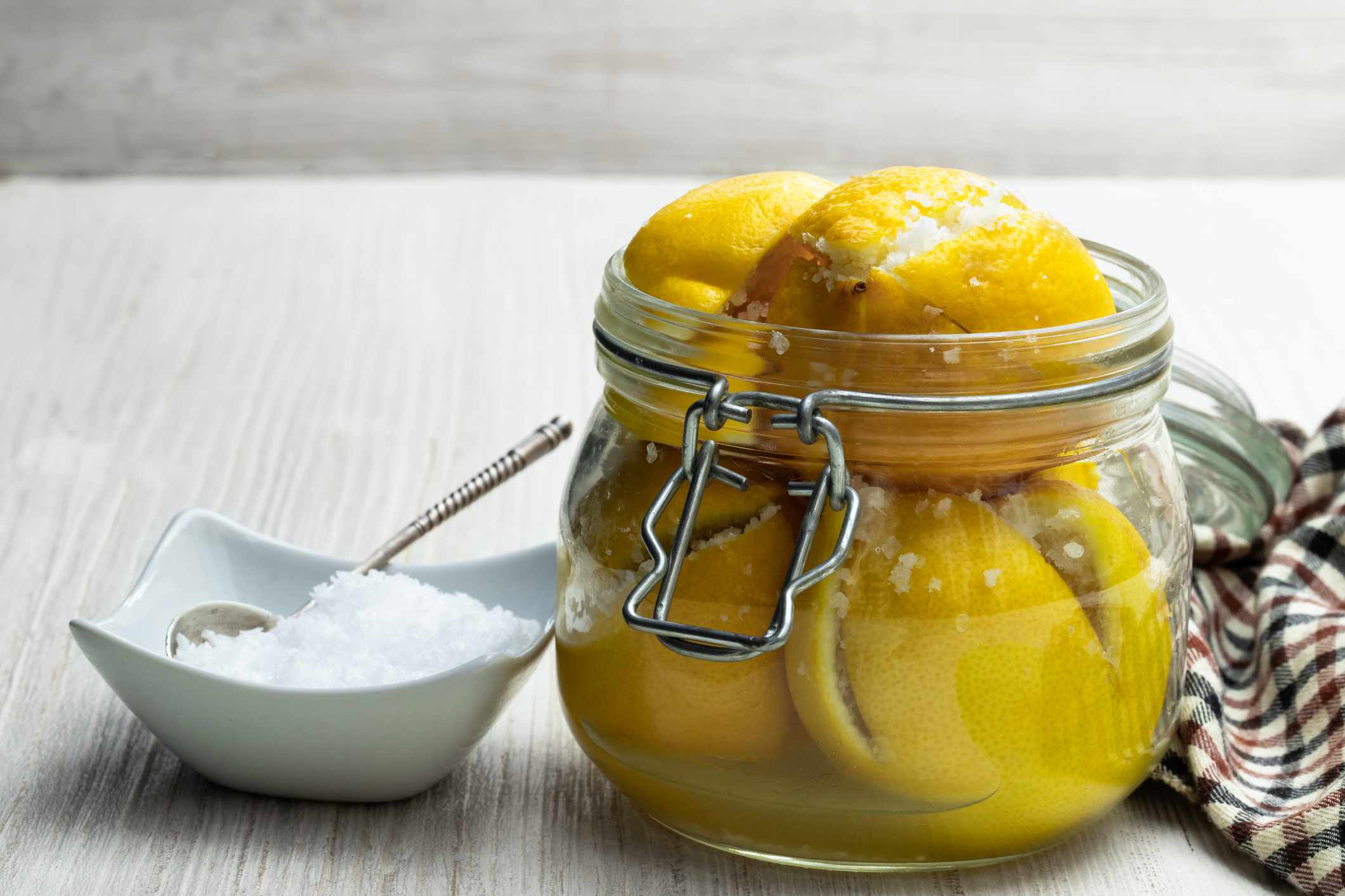 摩洛哥腌制柠檬在玻璃罐上白色的木桌