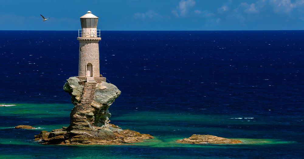希腊Andros的Tourlitis灯塔，在一个明亮的蓝色日子里