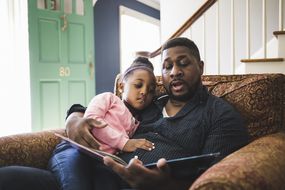 父亲和女儿正在读书＂width=