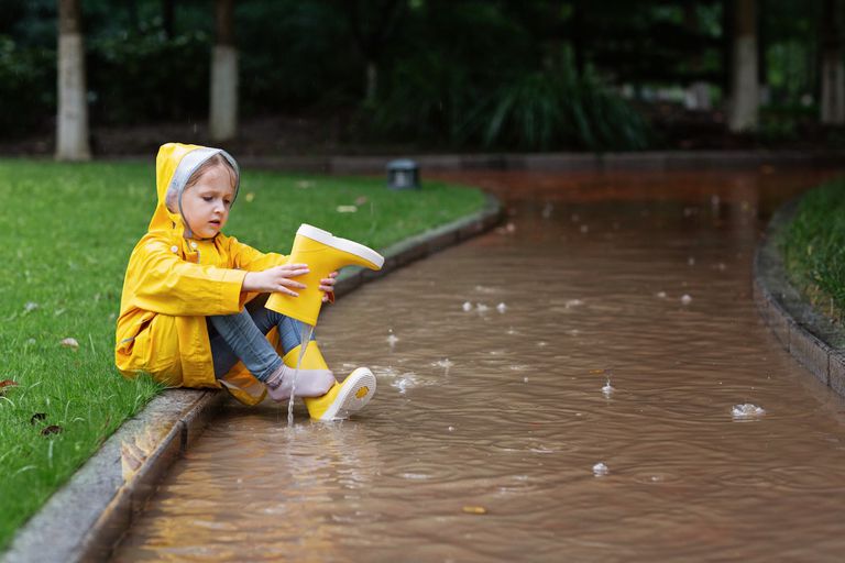 一个孩子正在清空她的雨靴