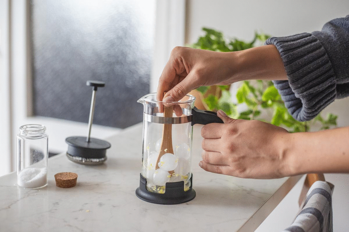 女子搅拌冰，柠檬皮和盐来清洁法式压滤咖啡机的玻璃动图