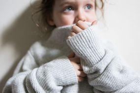 小女孩穿着一件超大的羊毛毛衣