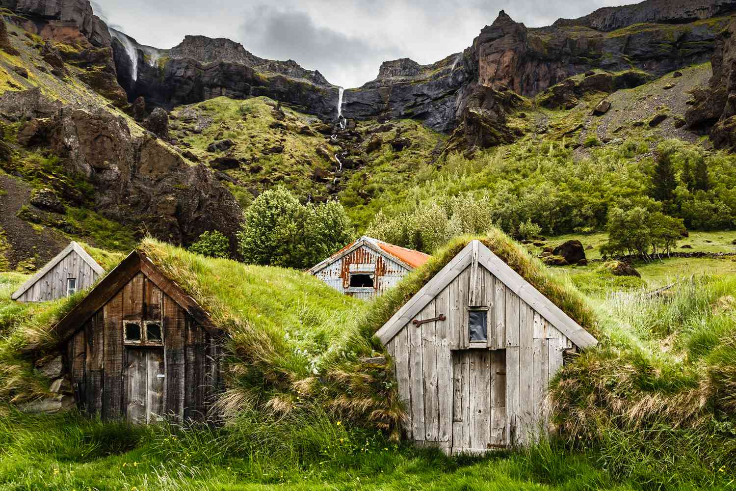 冰岛的地盘房屋和岩石峡谷和瀑布附近的背景Kalfafell茶香氤氲,冰岛南部