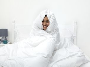 女人用白色的床罩包裹