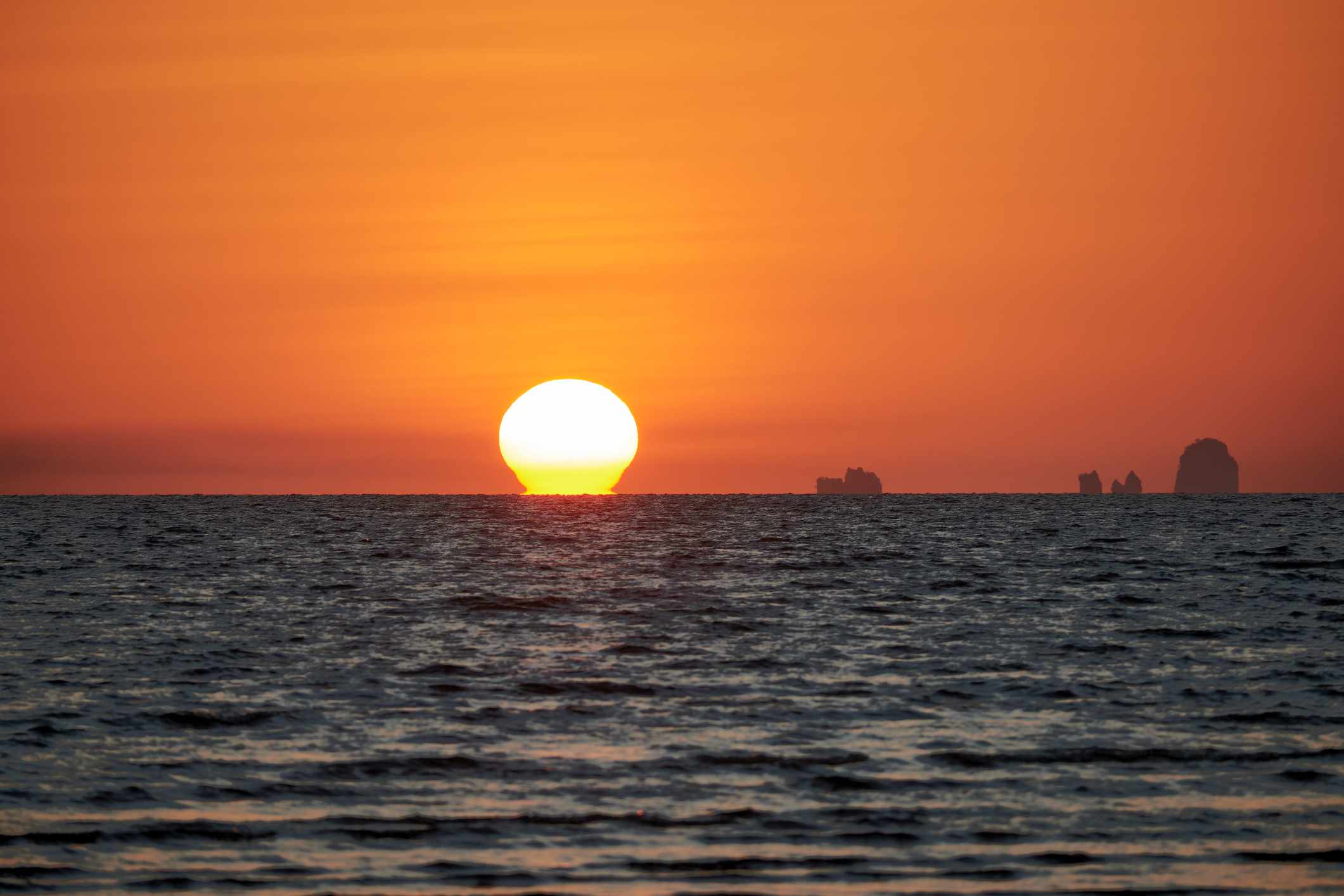 在泰国甲米的Hat Yao海滩，明亮的橙色天空和欧米茄的日落