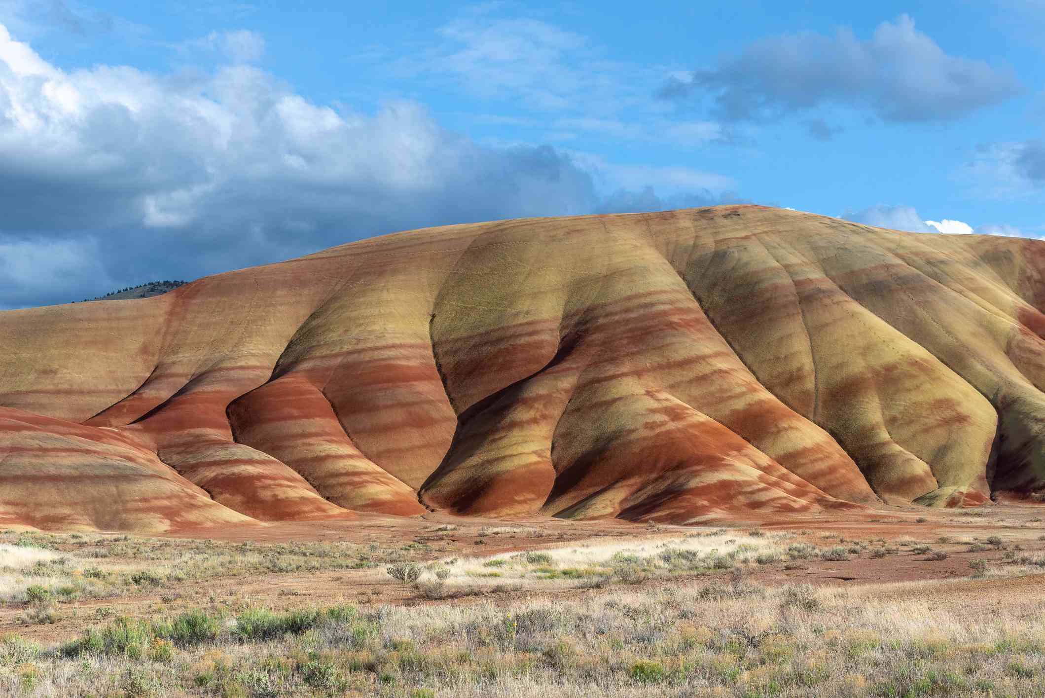 俄勒冈州沙漠高地上的一座小山，上面有黄色和红色的条纹