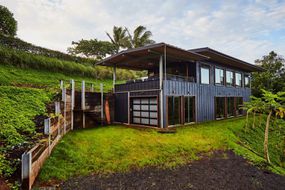 在热带绿色的山坡上，有一个上甲板的两层长方形房子