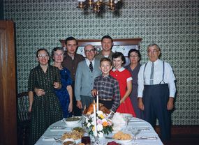 在假日餐桌前拍摄的复古20世纪50年代全家福＂width=