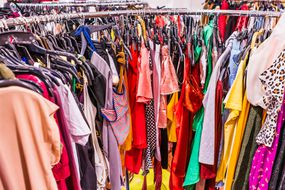 Colorful garments placed tightly together on a circular rack