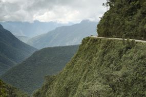 玻利维亚北云加斯，世界上最危险的道路——死亡之路上骑自行车的人。”width=