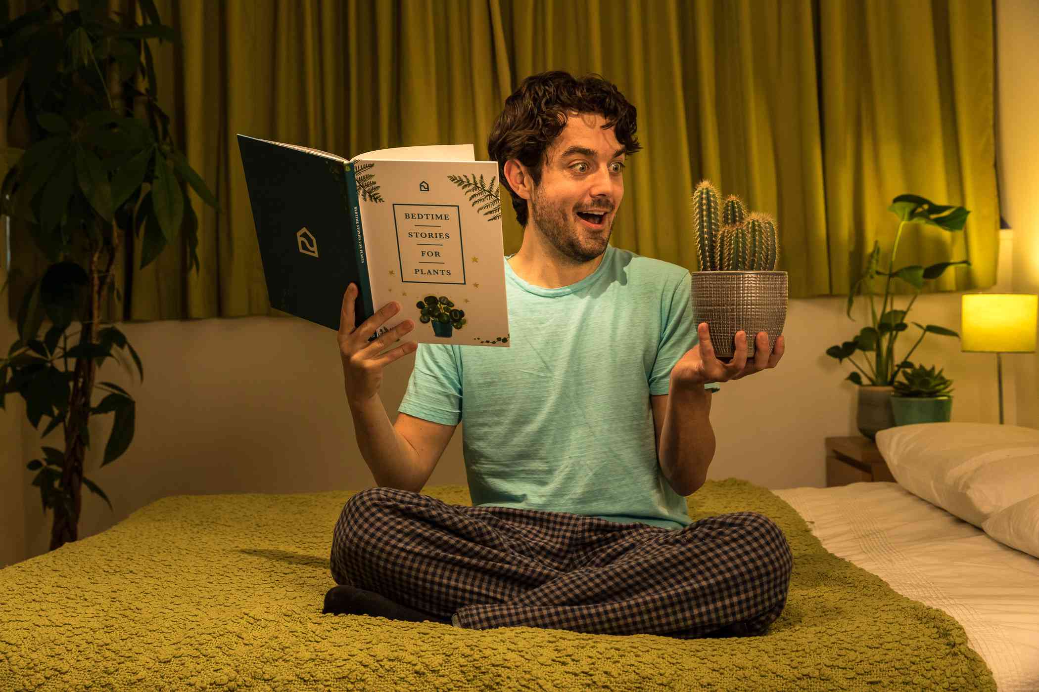男人躺在床上时，手里拿着一本书和一株植物