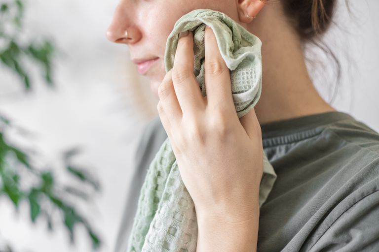 一名女子用绿色毛巾和自制卸妆水洁面
