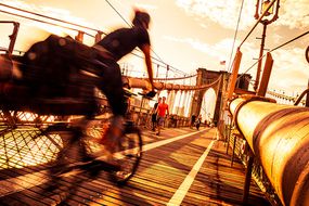在布鲁克林桥上骑自行车“width=