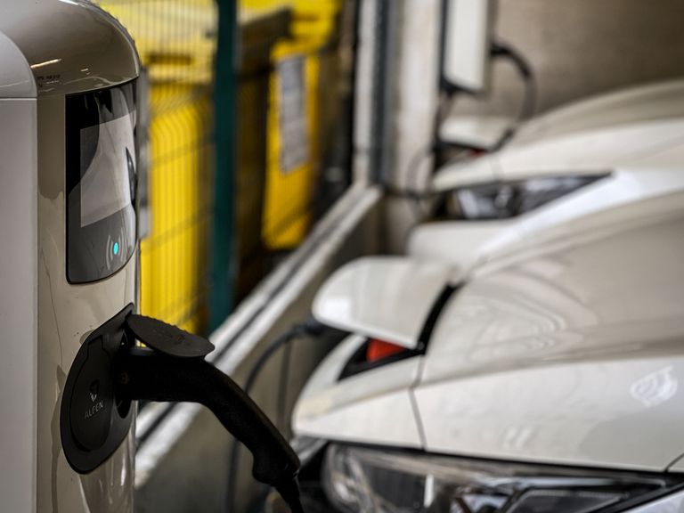 电动汽车于2022年1月22日在英格兰巴斯市的一个市中心停车场中被墙壁充电器收取。“class=