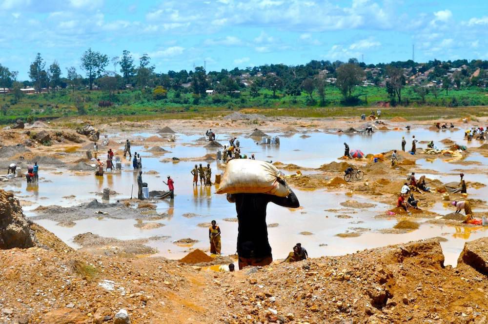 人洗铜矿石在泥泞的区域