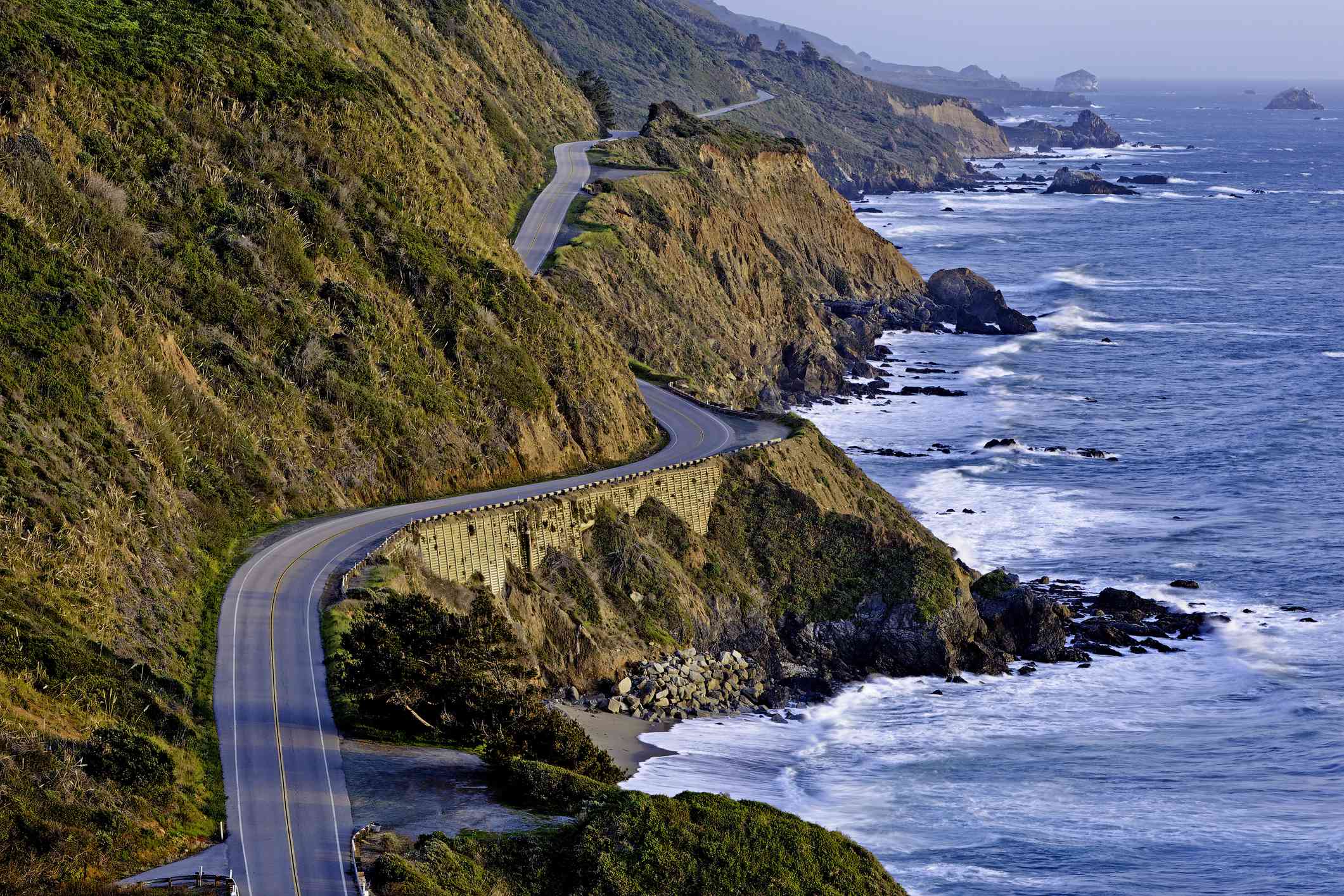 太平洋海岸公路沿着岩石海岸在日落