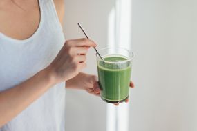 Young Woman Drinking Green Juice For Cleanse Diet