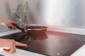 女性的手在厨房使用感应炉的细节