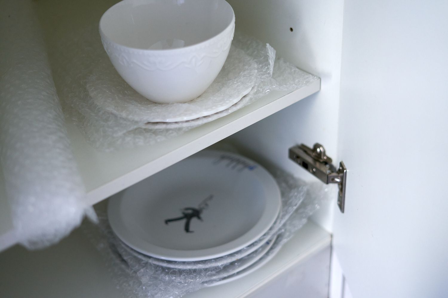 厨房橱柜里的盘子和碗用气泡膜包裹着