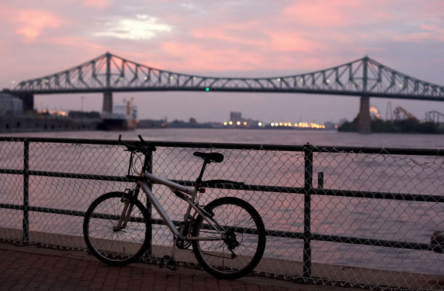 一辆自行车靠在栏杆前的雅克卡蒂亚桥日落时在蒙特利尔