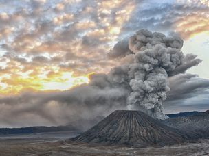 日出时，火山灰云从火山中升起